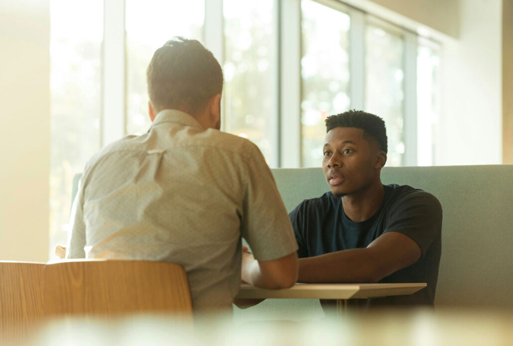 Two men talking in a one-on-one meeting.